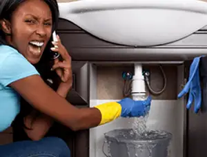 Emergency plumbing repair for a leaking sink drain under a bathroom vanity in Fresno, CA