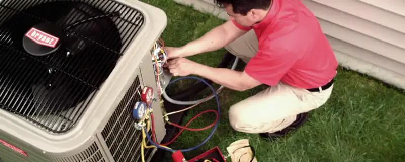 HVAC technician servicing an outdoor air conditioner unit in Fresno, CA