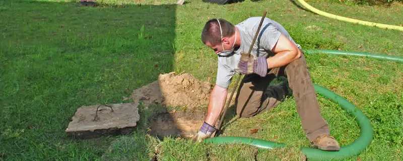 Septic pumping technician servicing a residential septic tank in Fresno, CA