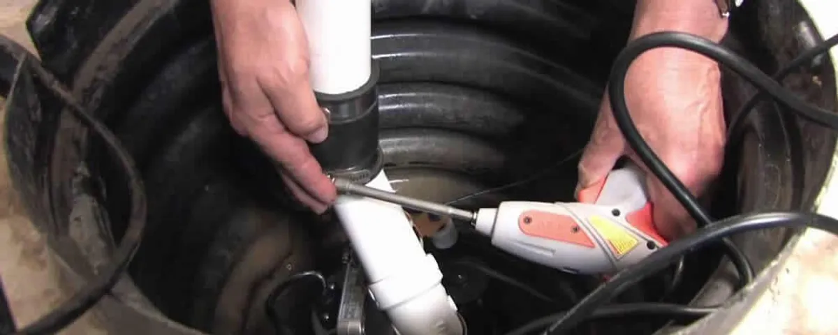 Sump pump installation technician connecting PVC discharge piping in Fresno, CA